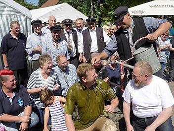 Genüsslich nahm Floßmeister Michael Thiemann mit Rodachwasser die Flößertaufe bei Pfarrer Andreas Krauter vor. Rechts daneben MdL Klaus Adelt. Im Hintergrund Bürgermeister Norbert Gräbner, Vorsitzender Friedrich Fricke und Ehrenvorsitzender Dieter Murmann.  Foto: Gerd Fleischmann