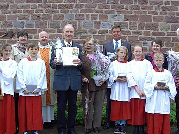 Claudia Röder, Vorsitzende des Pfarrgemeinderats, Pfarrer Jaroslaw Woch, den Diamantenen Mesner Adolf Schottdorf und seine Ehefrau Marliese, Dietmar Hack, Küstervorstand der Diözese Würzburg sowie Ministranten und Isolde und Richard Bahn (von links). Foto: Udo Sell