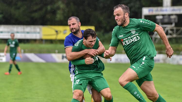 Wenn sich Zwei streiten, freut sich der Dritte:   Frohnlachs Spielertrainer Marcel Burkard (blaues Trikot) umklammert André Lörzer. Dessen Sander Teamkollege Thorsten Schlereth schnappt sich den Ball.  R. Evans