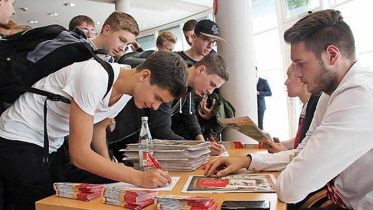Fabian Müller (rechts) von der Sparkasse gibt die Anmeldeunterlagen zum diesjährigen Planspiel Börse an die jeweiligen Gruppenleiter aus. Rund 180 Teams aus Kronach und Kulmbach werden teilnehmen.  Foto: Greiner