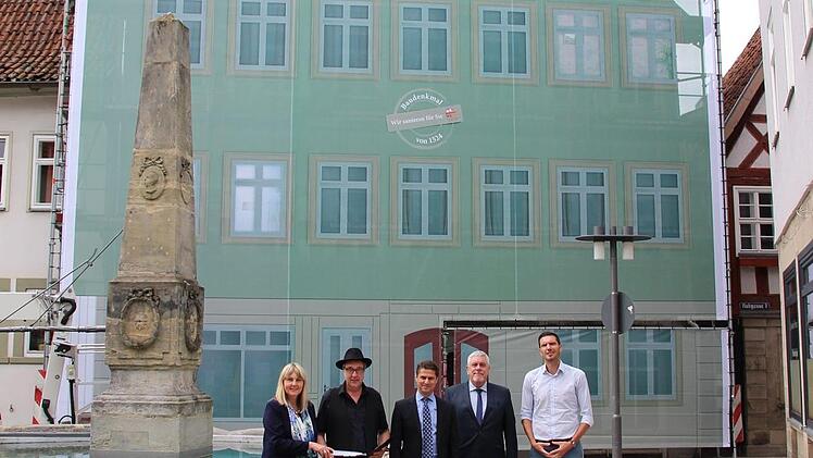 Zweite Bürgermeisterin Birgit Weber, Wohnbau-Architekt Rainer Wessels, Wohnbau-Chef Christian Meyer, Oberbürgermeister Norbert Tessmer und Sebastian Engelhardt, dessen Firma das Banner hergestellt und installiert hat, (von links) informierten über die Sanierung des Hauses Ketschengasse 42.  Foto: Ulrike Nauer
